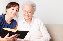 dementia caregiver in Edmonton reading to senior woman